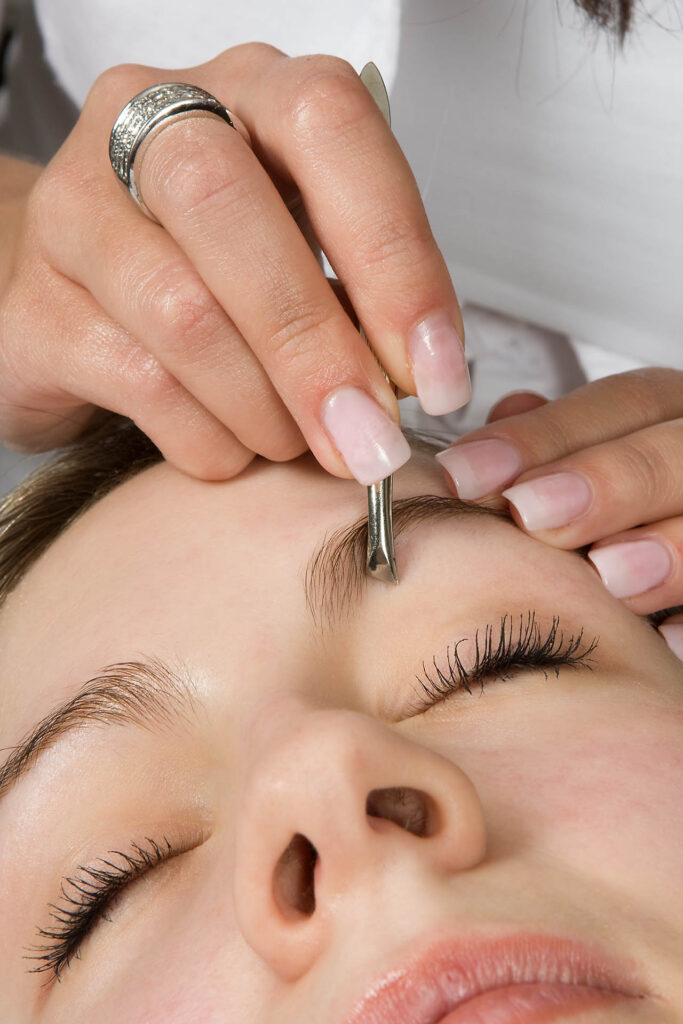 Beautician,Depilating,A,Woman's,Eyebrows,With,Tweezers